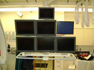 Front view of six (6) Modalixx G202MG LCD replacements of CRTs on ceiling suspension of Siemens Bi-Cor cath lab